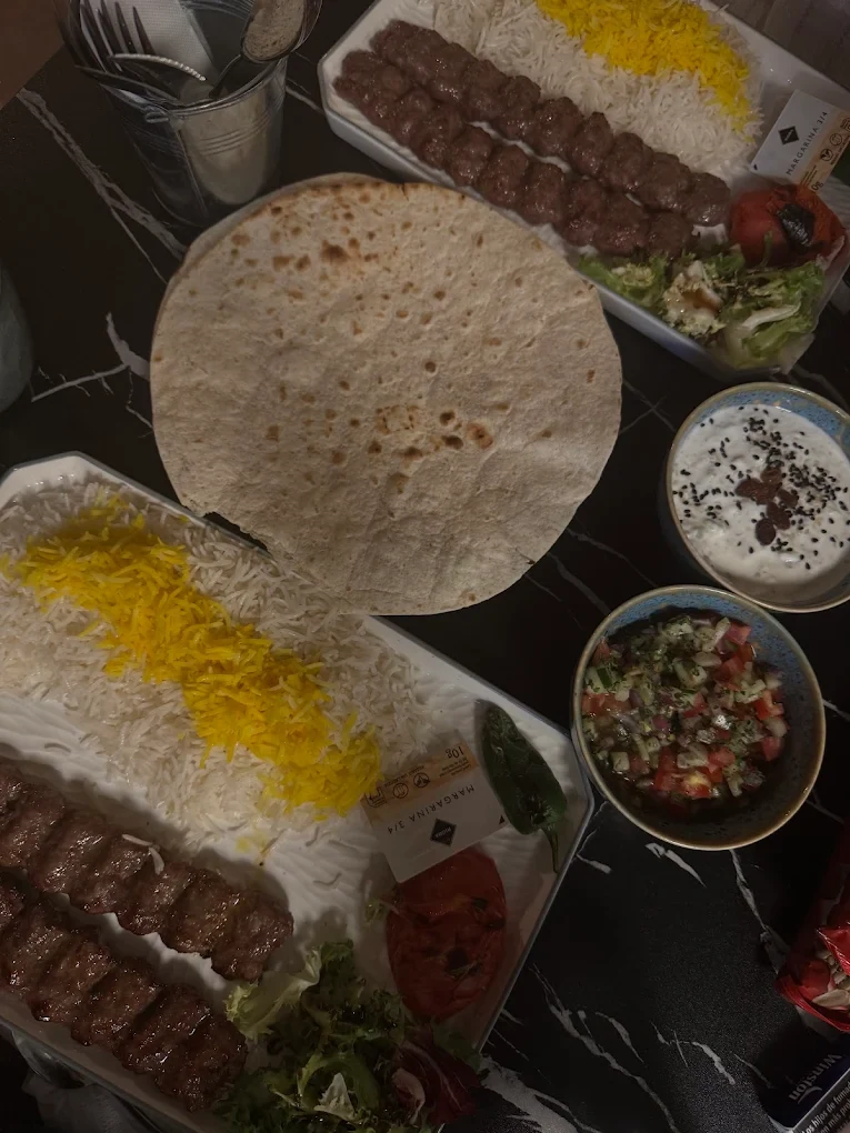 Una mesa de Casa Tehran con kebab, arroz y entrantes persas